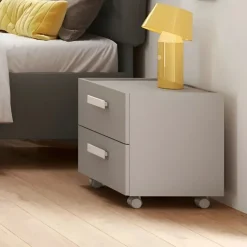 Comodino con ruote e 2 cassetti per camerette con maniglie sagomate disponibile in 4 colori